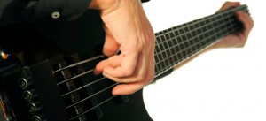 detail of the musician and his instrument while playing electric bass guitar
